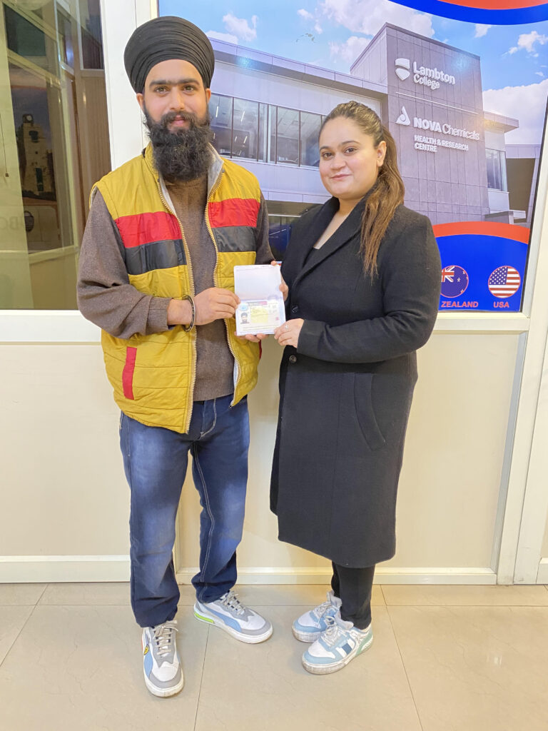 Client receiving an approved visa at the Spearhead International office